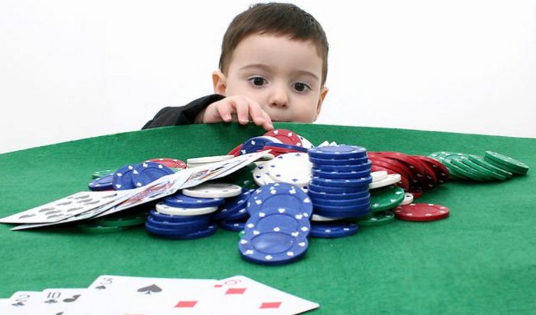 Un niño con cartas y fichas de casino